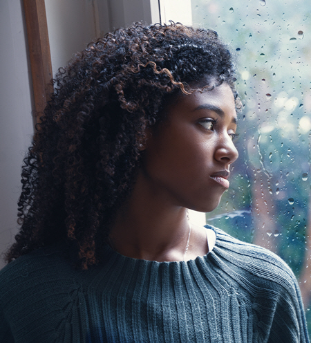 woman needing anxiety therapy looking out rainy window