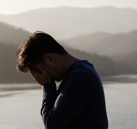 man with head in hands standing outside; Breathwork Therapy for Depression Relief; 